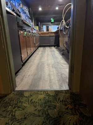 Luxury vinyl plank flooring in commercial kitchen with stainless steel cabinetry