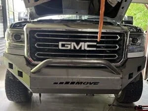 Custom steel front bumper with grille guard on GMC truck, black powder coat finish