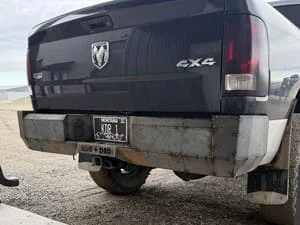 Custom welded steel rear bumper on pickup truck, black powder coat finish