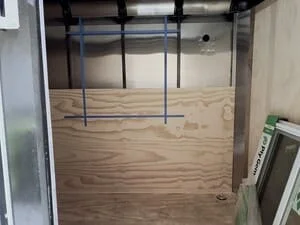 Steel frame structure with welded tubing and plywood flooring in enclosed space