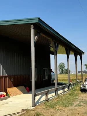 Steel frame agricultural shelter with green metal roof and open sides