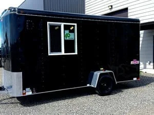 Black steel enclosed trailer with white window frame and aluminum accents