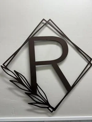 Steel letter R in diamond frame with leaf accents, welded steel signage