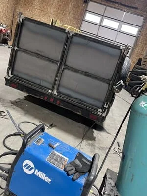 Steel utility trailer with dual hinged gates and welded frame construction