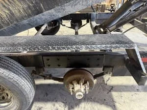 Trailer undercarriage showing new axle assembly and welded steel frame reinforcement